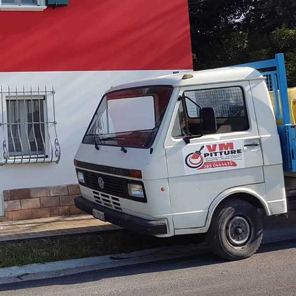 Il furgone di VM Pitture parcheggiato davanti a una casa con la facciata appena tinteggiata